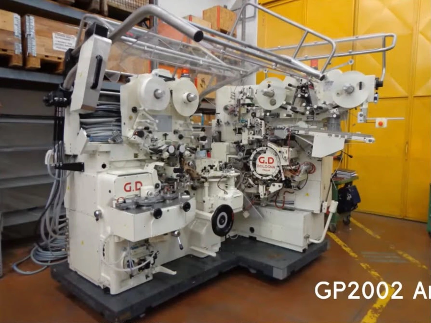 IGEMA Technology GmbH&Co.KG - Maschinenbau & Verpackungstechnik Service - GP2002 Nachher: ​​Generalüberholte, hochpräzise weiße Hochgeschwindigkeits-Verpackungsmaschine mit präzisen mechanischen Komponenten und Folienrollen.
