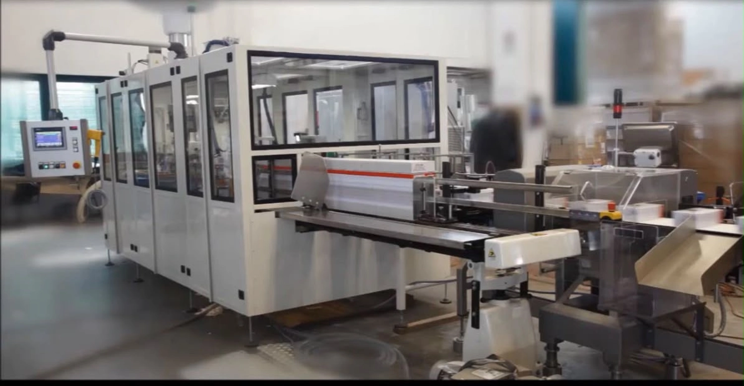 IGEMA Technology GmbH&Co.KG - Maschinenbau & Verpackungstechnik Service - Eine geschlossene, industrielle, automatisierte Verpackungs- und Produktionslinie mit einem Förderbandsystem aus Edelstahl.